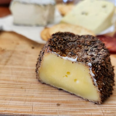 Peppered cheese cut open on a board
