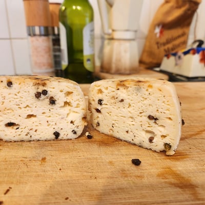 A cheese cut in half on a wooden board