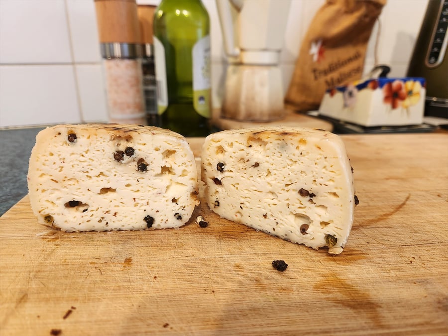 Sheep's cheese cut in half on a board